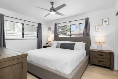 Rest easy in the spacious primary bedroom featuring a plush king-sized bed, soft linens, and a serene vibe for the perfect night's sleep.